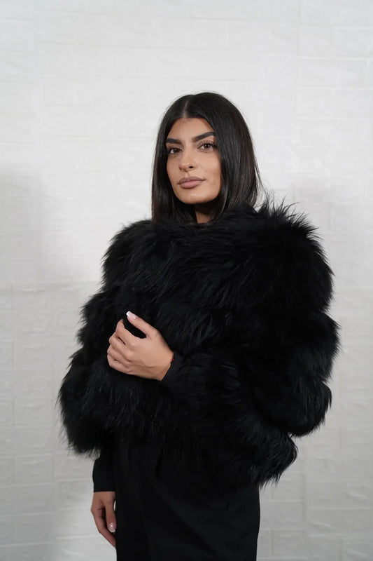 Alpaca fur jacket black close-up texture showing black alpaca pile depth and horizontal leather strip construction between fur rows — Greek craftsmanship, TatiFurs