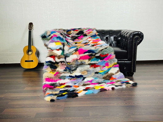 Fox Fur Blanket Throw Colorful - Tatifurs draped over a couch, showcasing vibrant multicolor patterns.
