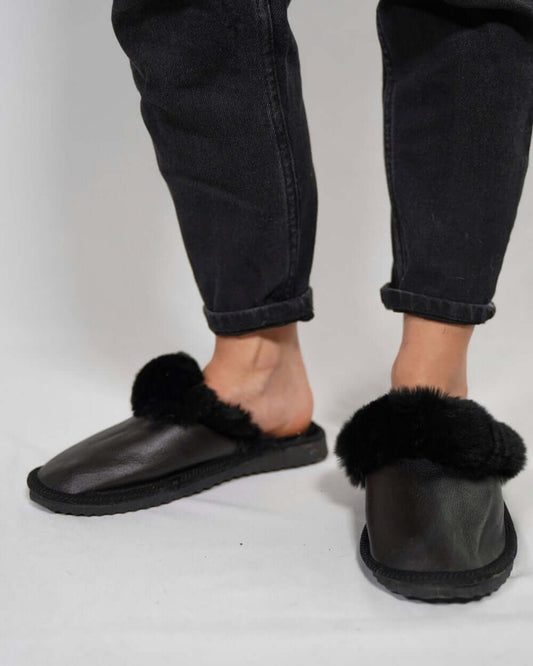 Leather Sheepskin Slippers Black - Tatifurs worn by a person, showcasing the luxurious design and comfort of genuine leather and wool.