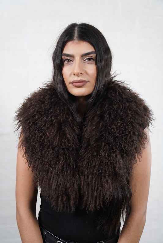 Mongolian Sheepskin Collar Dark Brown — Curly Lamb Fur worn by a woman, front view of the long curly deep chocolate brown Tibetan lamb fur framing the face and shoulders, TatiFurs