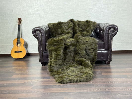Fox Fur Blanket Throw Green - Tatifurs draped over a chair, showcasing its rich green color and luxurious texture.
