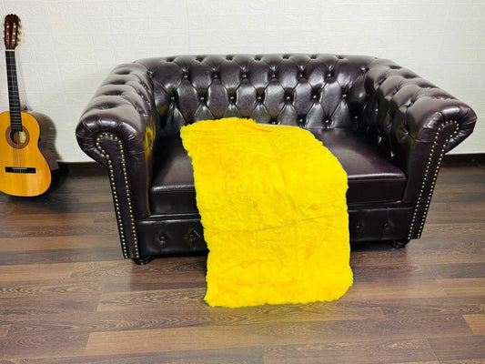 Rex Rabbit Blanket Throw Full Skin Yellow - Tatifurs displayed on a brown leather couch.