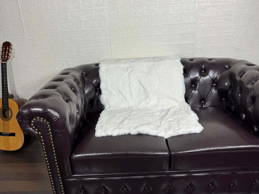 Rex Rabbit Blanket Throw Full Skin White - Tatifurs on a plush sofa, showcasing its luxury and softness.