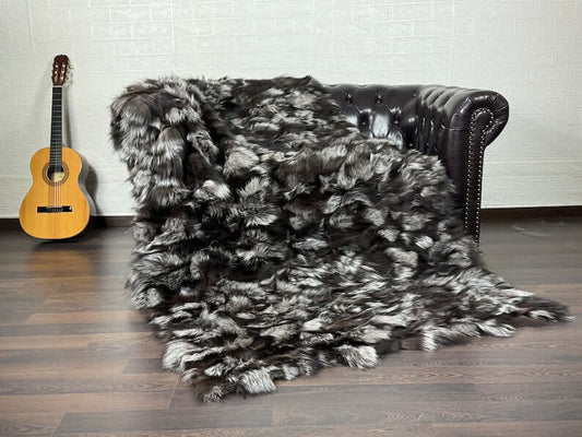 Fox Fur Blanket Throw Double Sided Silver - Tatifurs displayed on a sofa with a guitar in the background.