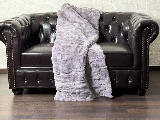 Rabbit Blanket Throw Rex Purple - Tatifurs draped over a luxurious leather sofa, showcasing the soft purple hues.
