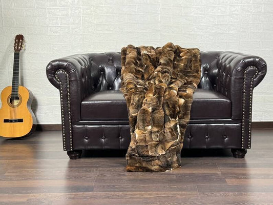 Rabbit Blanket Throw Rex Orilax - Tatifurs draped over a brown leather couch with a guitar in the background.
