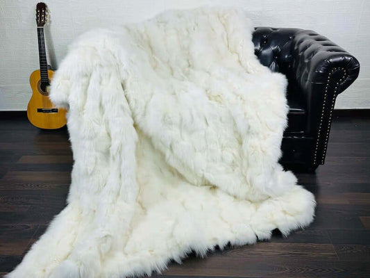 Fox Fur Blanket Throw Double Sided White - Tatifurs displayed over a black leather sofa with an acoustic guitar.