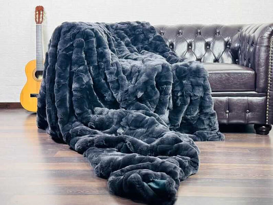 Rabbit Blanket Throw Rex Gray - Tatifurs draped on a couch with a guitar in the background, showcasing luxurious texture.