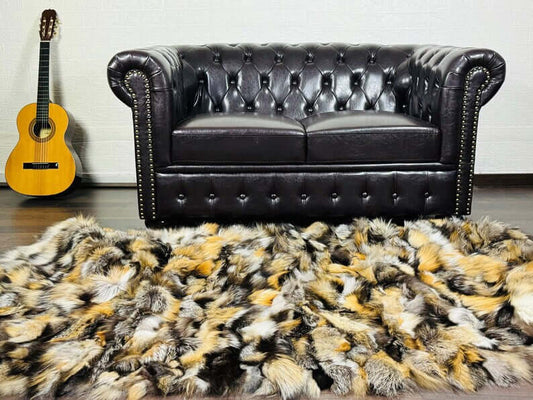 Fox Fur Blanket Throw Double Sided Gross Natural draped on floor in front of luxurious leather sofa.