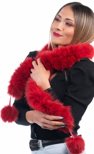 Woman wearing red fox fur scarf with pom poms showing bold vivid red color