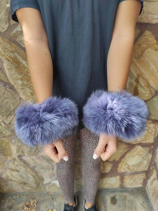 Woman wearing purple fox fur cuffs on wrists showing bold regal color