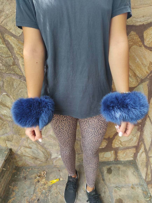 Woman wearing blue fox fur cuffs on wrists showing rich vibrant blue color