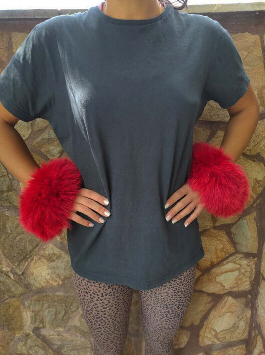 Woman wearing red fox fur cuffs on wrists showing bold vivid red color