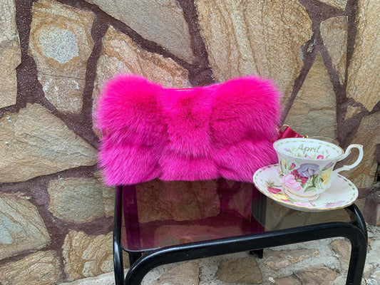 Fuchsia Fox Fur Bag - Tatifurs displayed next to a floral teacup on a black table.