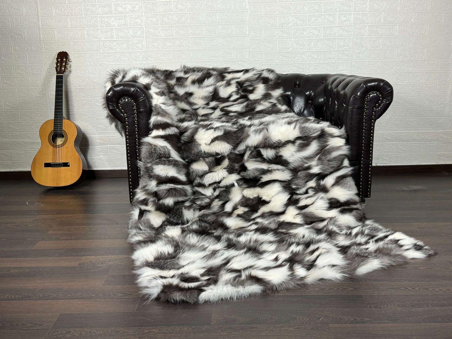 Fox Fur Blanket Throw Black Silver White - Tatifurs draped over a couch with a guitar in the background.