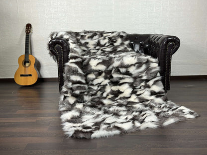 Fox Fur Blanket Throw Black Silver White - Tatifurs draped over a couch with a guitar in the background.