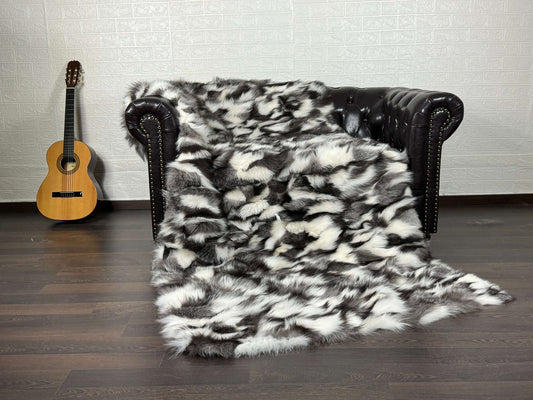 Fox Fur Blanket Throw Black Silver White - Tatifurs draped over a couch with a guitar in the background.