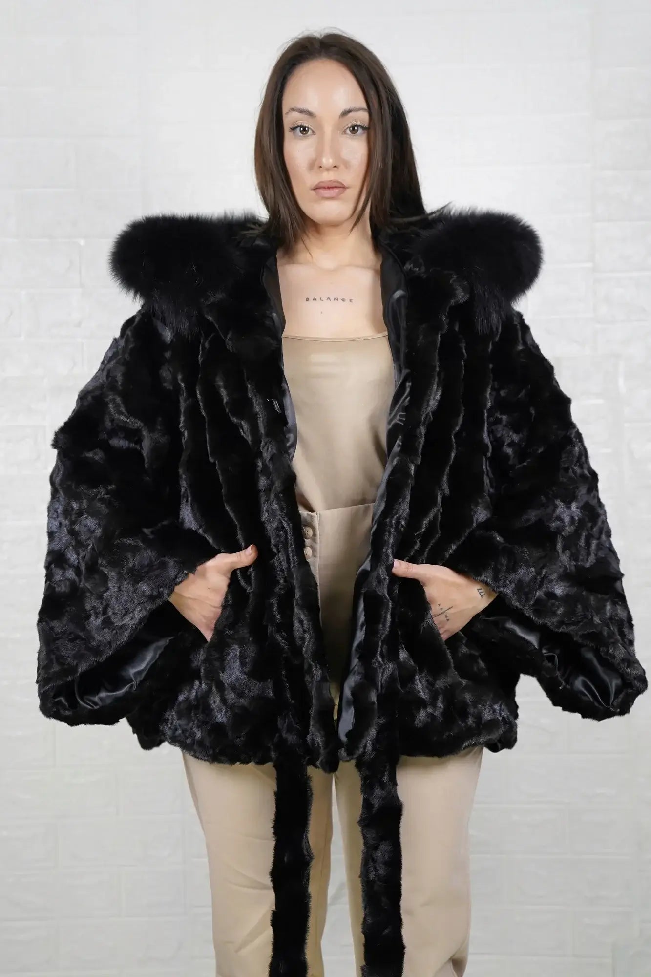 Mink fur cape black fox trim hood shown from the side displaying hip level silhouette and black fox trim drape around hooded frame — Greek craftsmanship, TatiFurs
