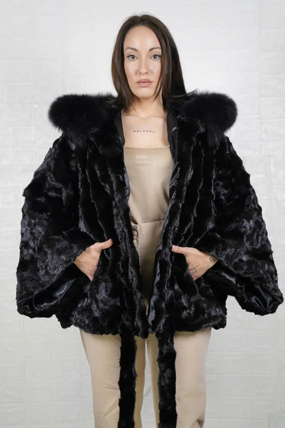 Mink fur cape black fox trim hood shown from the side displaying hip level silhouette and black fox trim drape around hooded frame — Greek craftsmanship, TatiFurs
