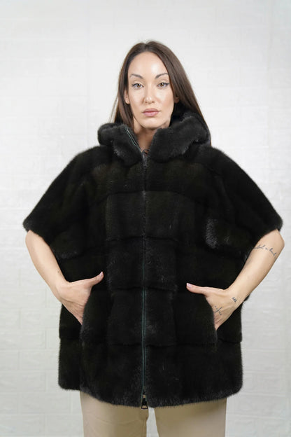 Mink fur cape dark green worn over evening dress showing dramatic hooded silhouette and deep organic dark green tone
