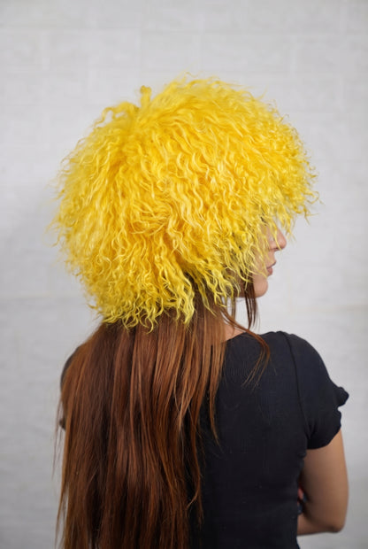 Mongolian Sheepskin Hat Yellow — Curly Lamb Fur, One Size three-quarter back view showing the warm sunflower yellow curls covering the crown and nape — Greek craftsmanship, TatiFurs