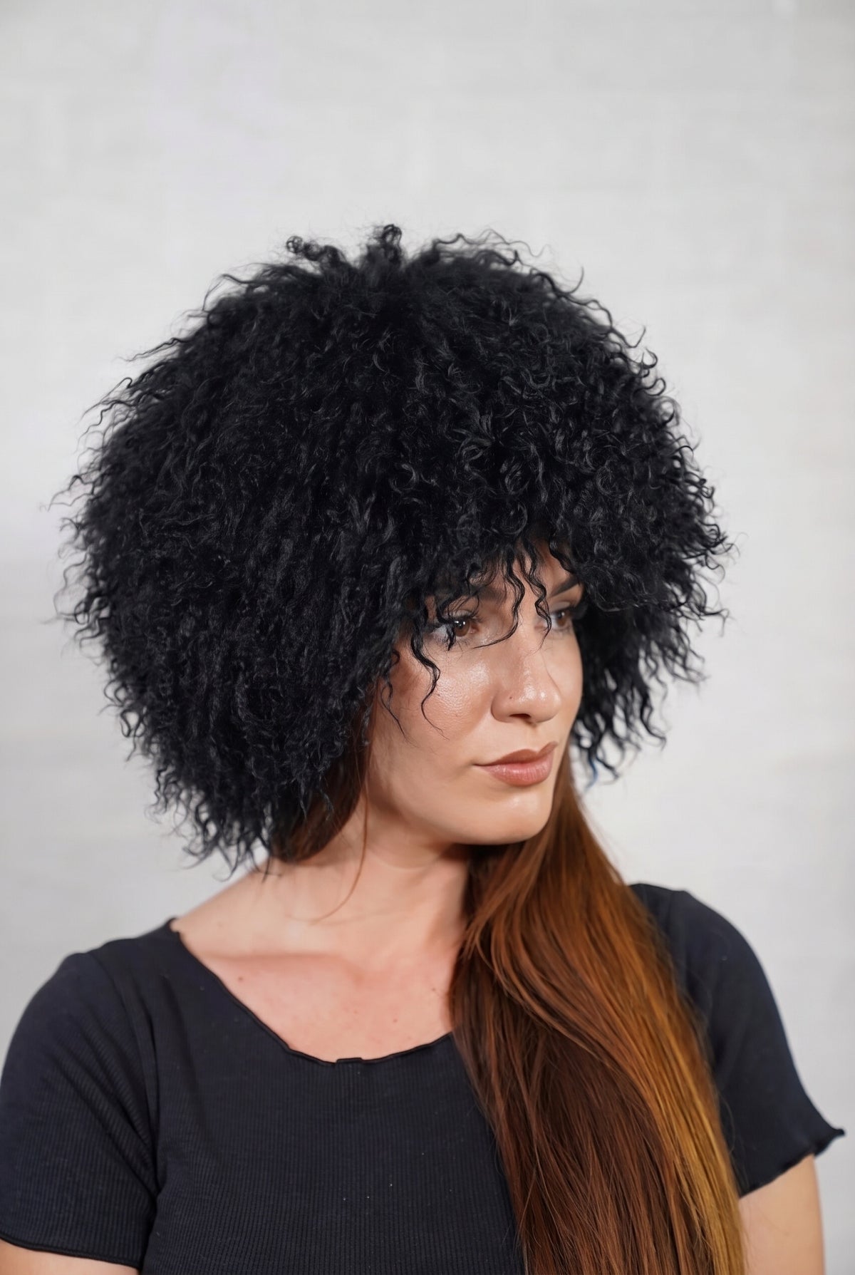 Mongolian Sheepskin Hat Black — Curly Lamb Fur, One Size in profile displaying the volume and length of the deep jet black curly sheepskin pile over the ear — TatiFurs