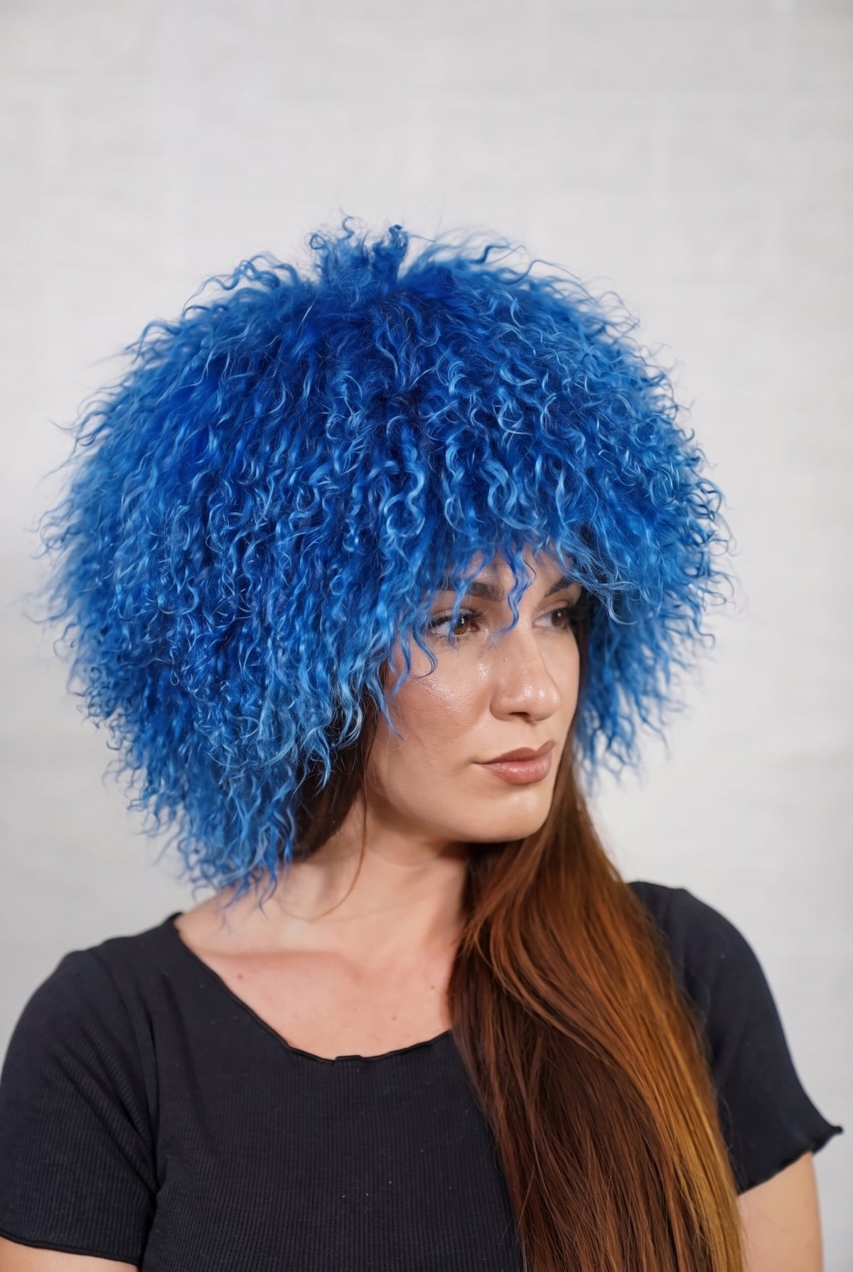 Mongolian Sheepskin Hat Blue — Curly Lamb Fur, One Size in profile displaying the volume and length of the rich cobalt blue curly sheepskin pile over the ear — TatiFurs