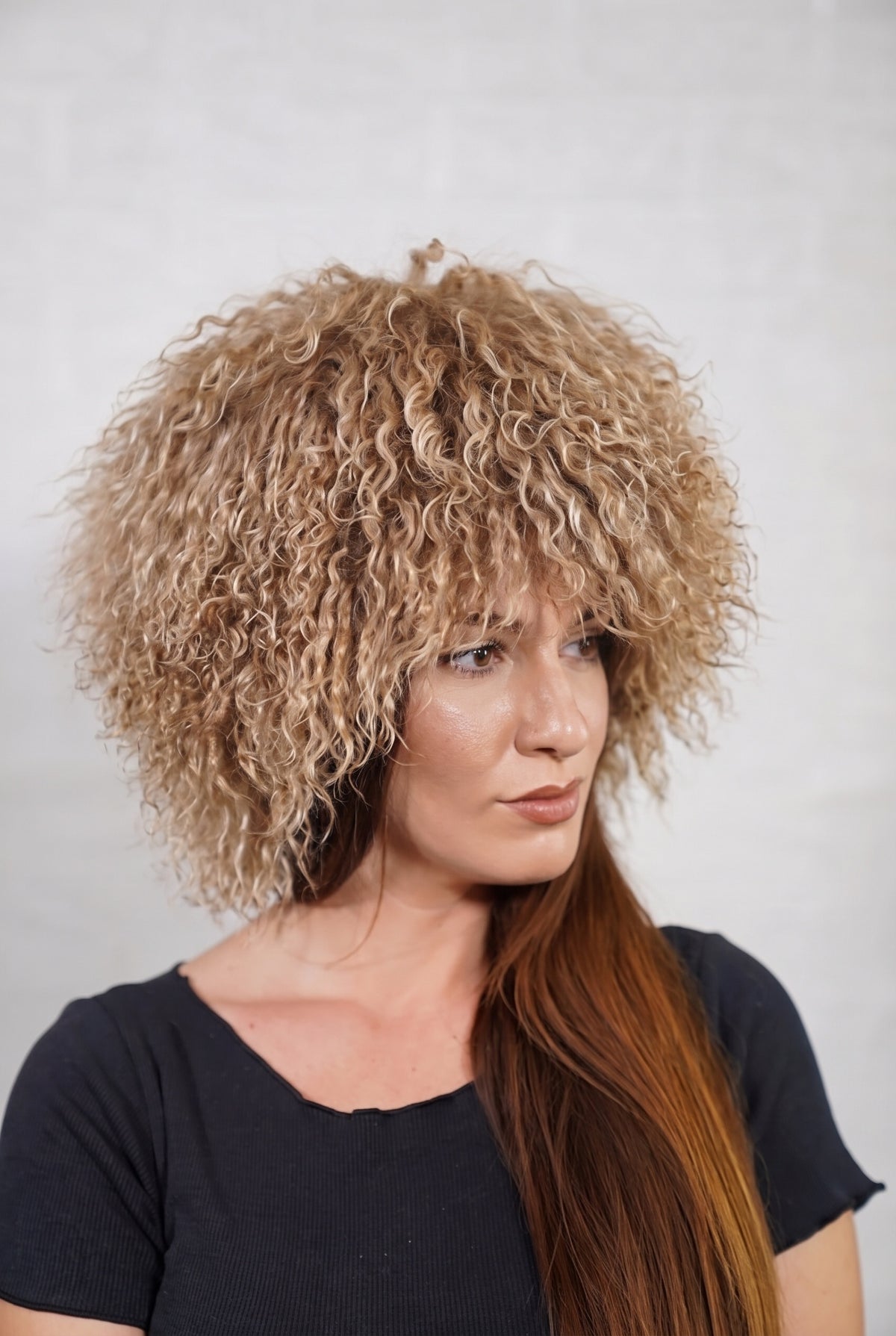 Mongolian Sheepskin Hat Light Brown — Curly Lamb Fur, One Size in profile displaying the volume and length of the milky caramel light brown curly sheepskin pile over the ear — TatiFurs