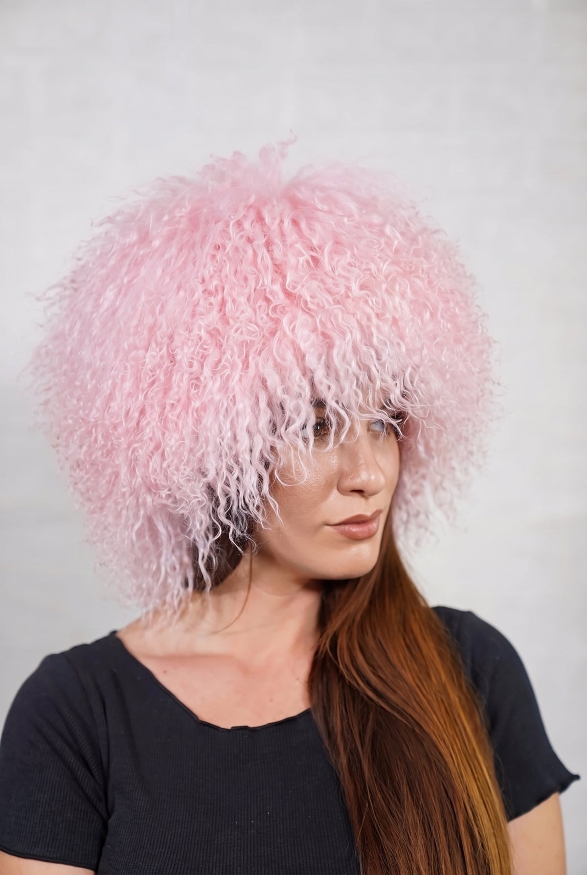 Mongolian Sheepskin Hat Pink — Curly Lamb Fur, One Size in profile displaying the volume and length of the pale powder pink curly sheepskin pile over the ear — TatiFurs