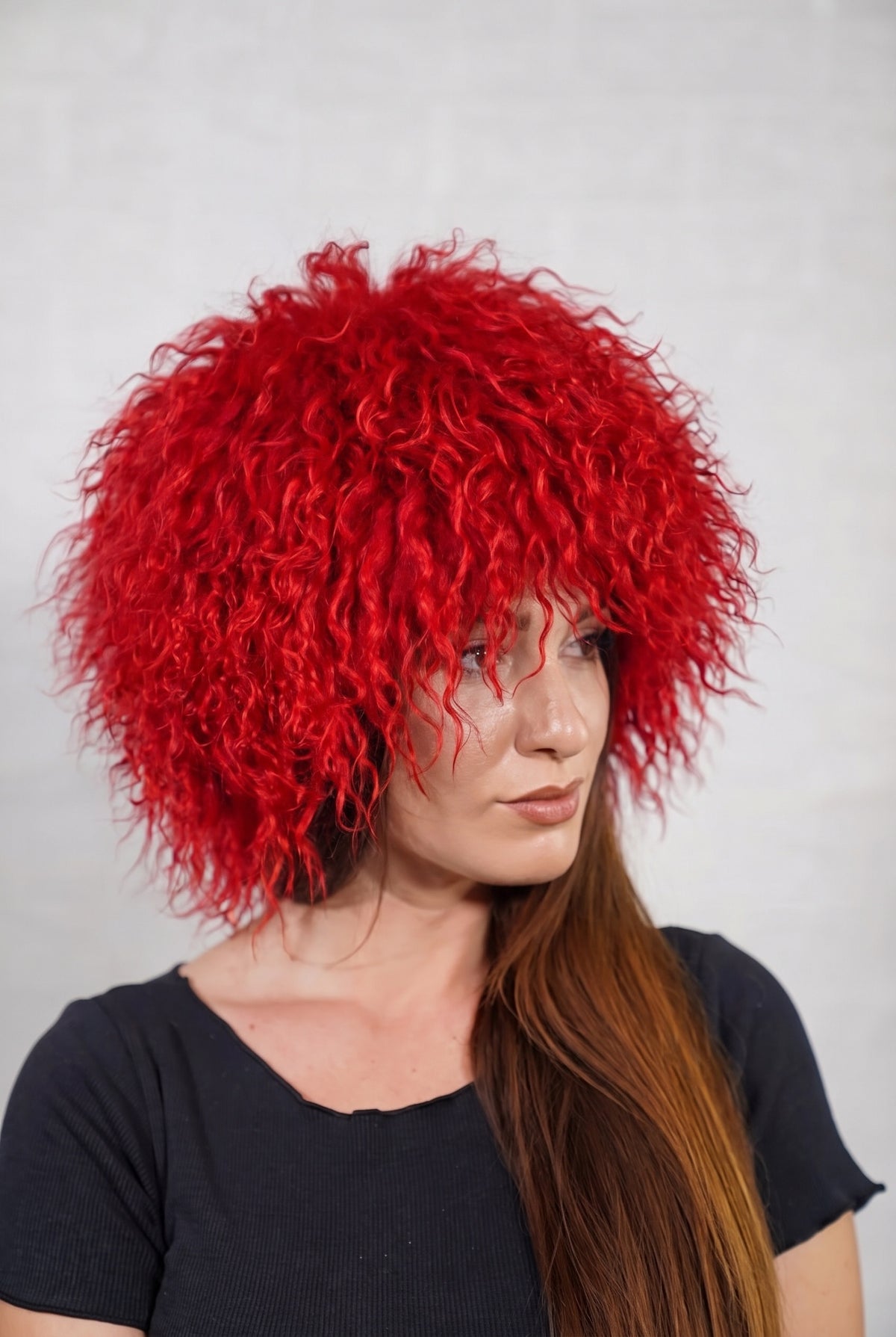 Mongolian Sheepskin Hat Red — Curly Lamb Fur, One Size in profile displaying the volume and length of the vivid scarlet red curly sheepskin pile over the ear — TatiFurs