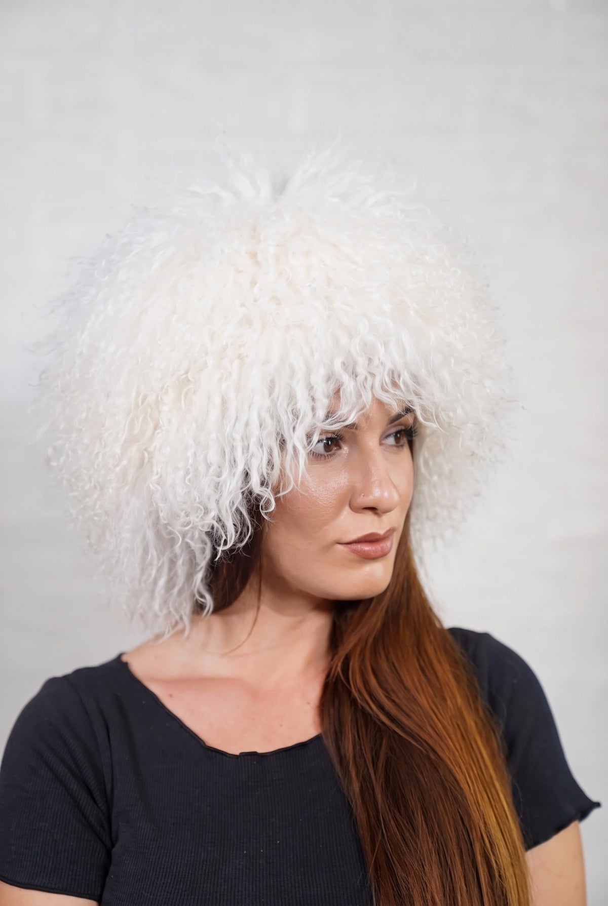 Mongolian Sheepskin Hat White — Curly Lamb Fur, One Size in profile displaying the volume and length of the pure snow white curly sheepskin pile over the ear — TatiFurs