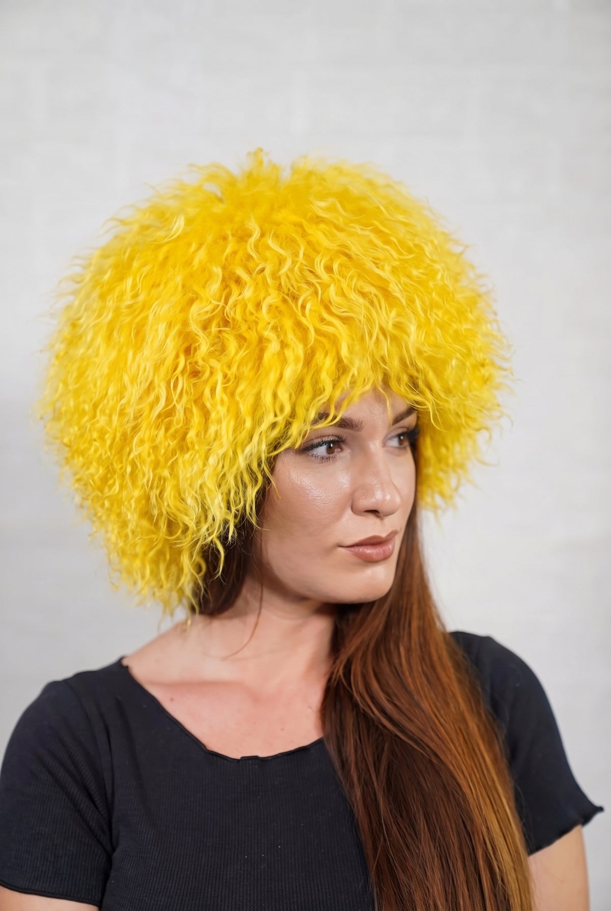 Mongolian Sheepskin Hat Yellow — Curly Lamb Fur, One Size in profile displaying the volume and length of the warm sunflower yellow curly sheepskin pile over the ear — TatiFurs