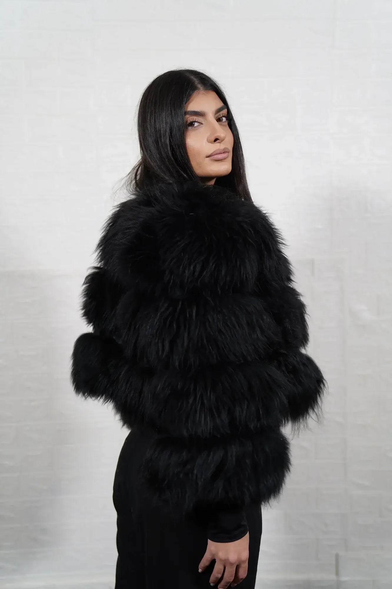 Alpaca fur jacket black women shown full length from front displaying bomber neckline and button closure in horizontal leather framed black alpaca rows — Greek craftsmanship, TatiFurs
