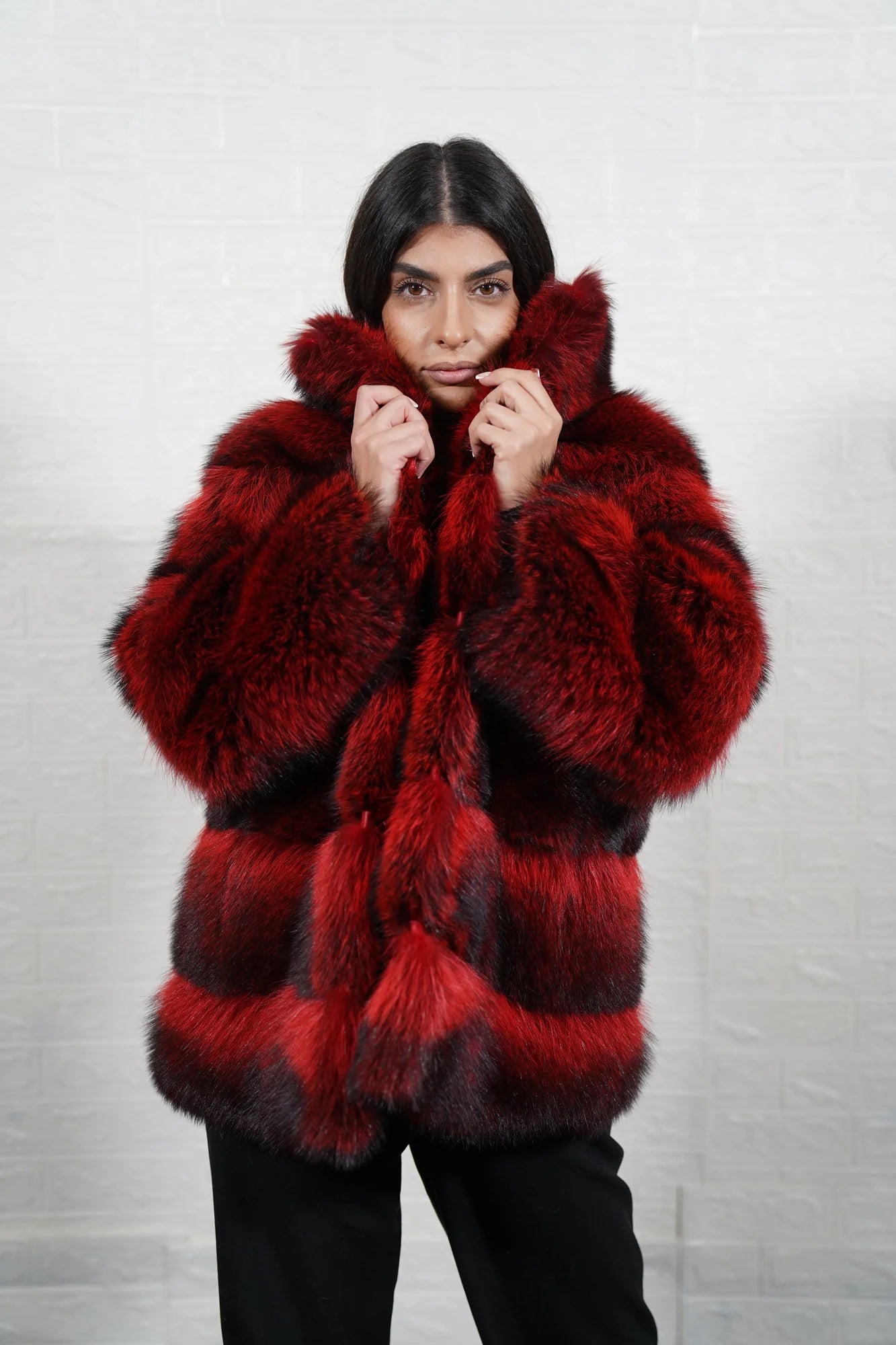 Raccoon fur jacket red black shown from the side displaying below hip silhouette and dramatic red black raccoon pile drape from collar to hem — Greek craftsmanship, TatiFurs
