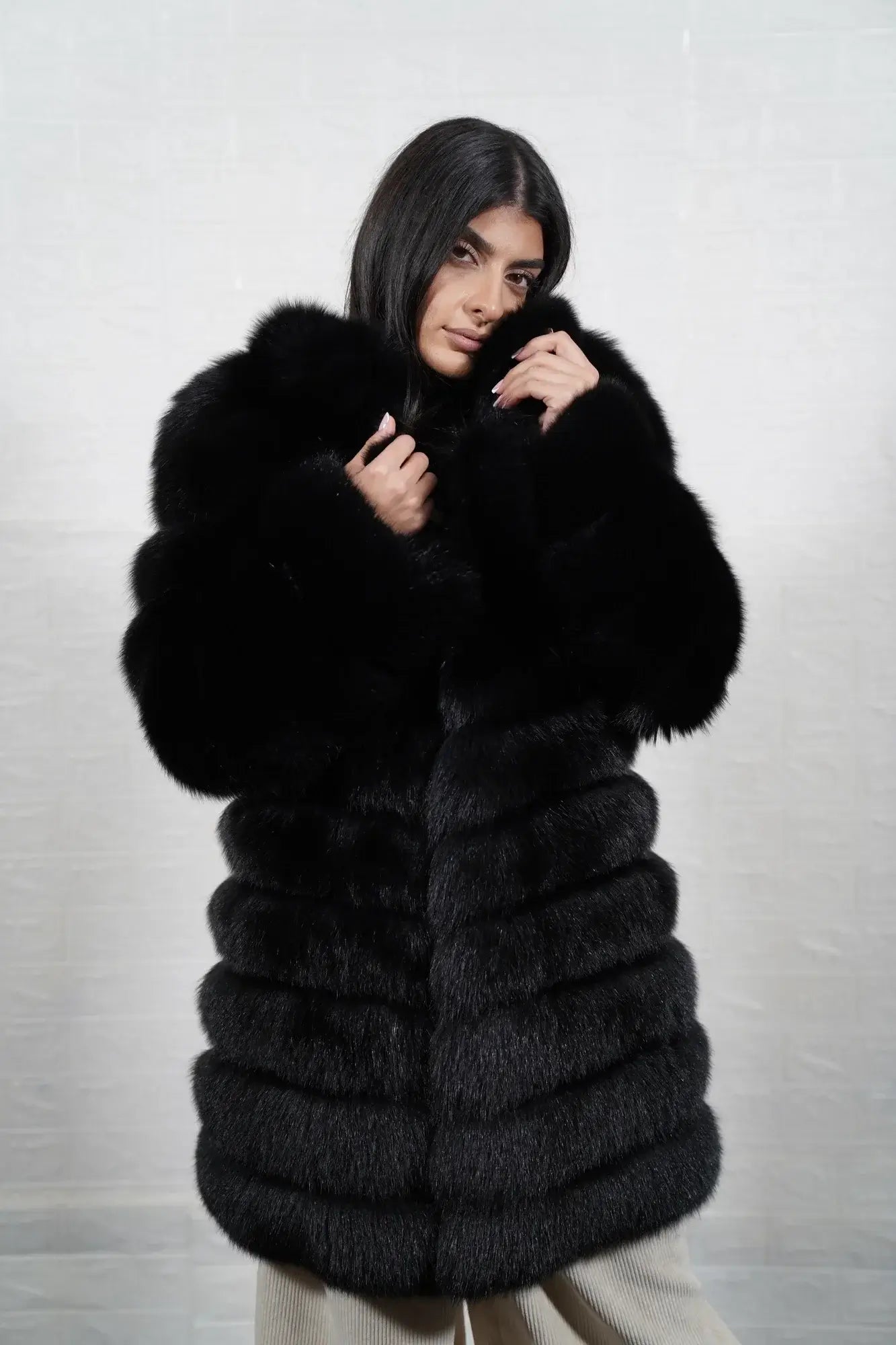 Fox fur coat black displaying full skin black fox horizontal rows with clean leather strips and knee length collarless silhouette — Greek craftsmanship, TatiFurs
