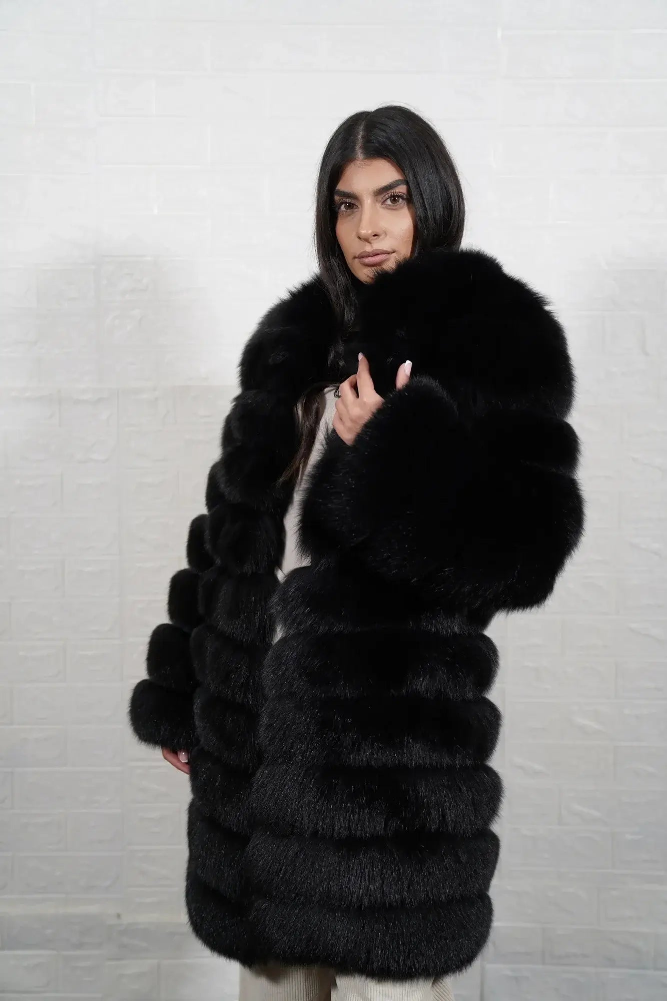Fox fur coat black shown from the back displaying full knee length silhouette and horizontal leather strip construction across black fox rows — Greek craftsmanship, TatiFurs
