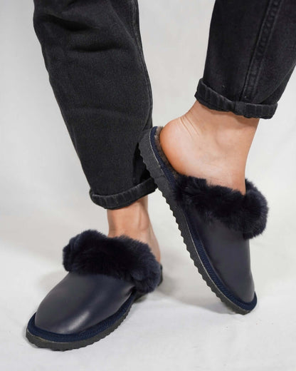 Sheepskin Wool Leather Fur Slippers Blue for Women worn with dark jeans, showcasing the style and comfort of the slippers.