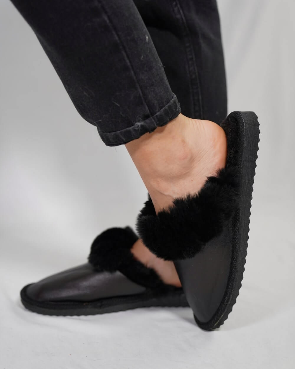 Leather Sheepskin Slippers Black - Tatifurs worn on a foot, showcasing comfort and style.