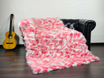Fox Fur Blanket Throw Pink White - Tatifurs draped over a couch, showcasing its soft pink and white colors.