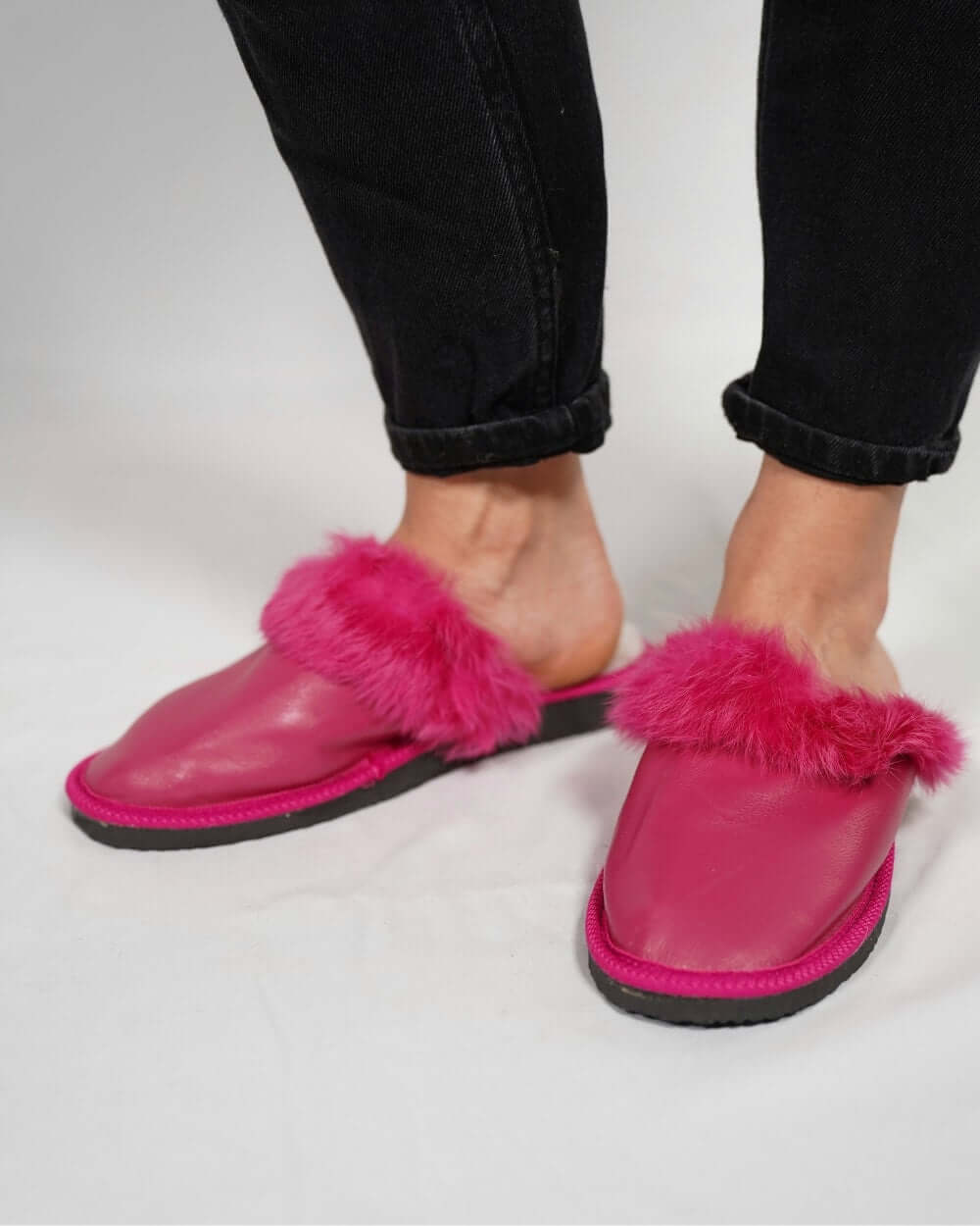 Sheepskin Wool Leather Fur Slippers Fuchsia for Women worn with casual jeans.