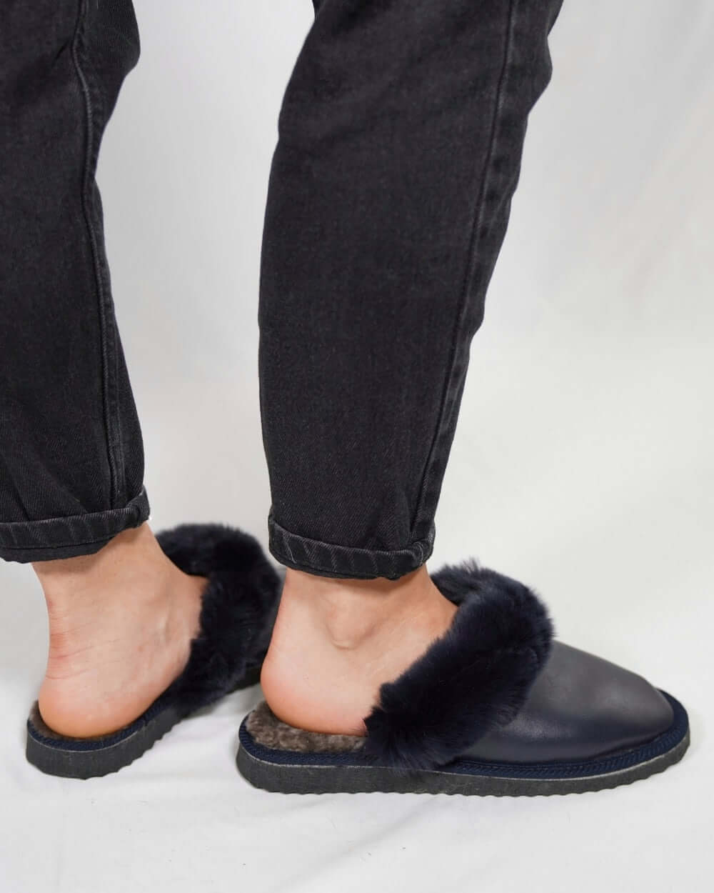 Sheepskin Wool Leather Fur Slippers Blue for Women worn with black jeans.