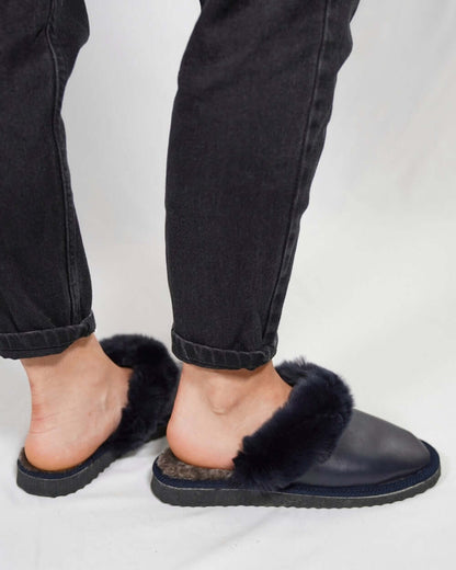 Sheepskin Wool Leather Fur Slippers Blue for Women worn with black jeans.