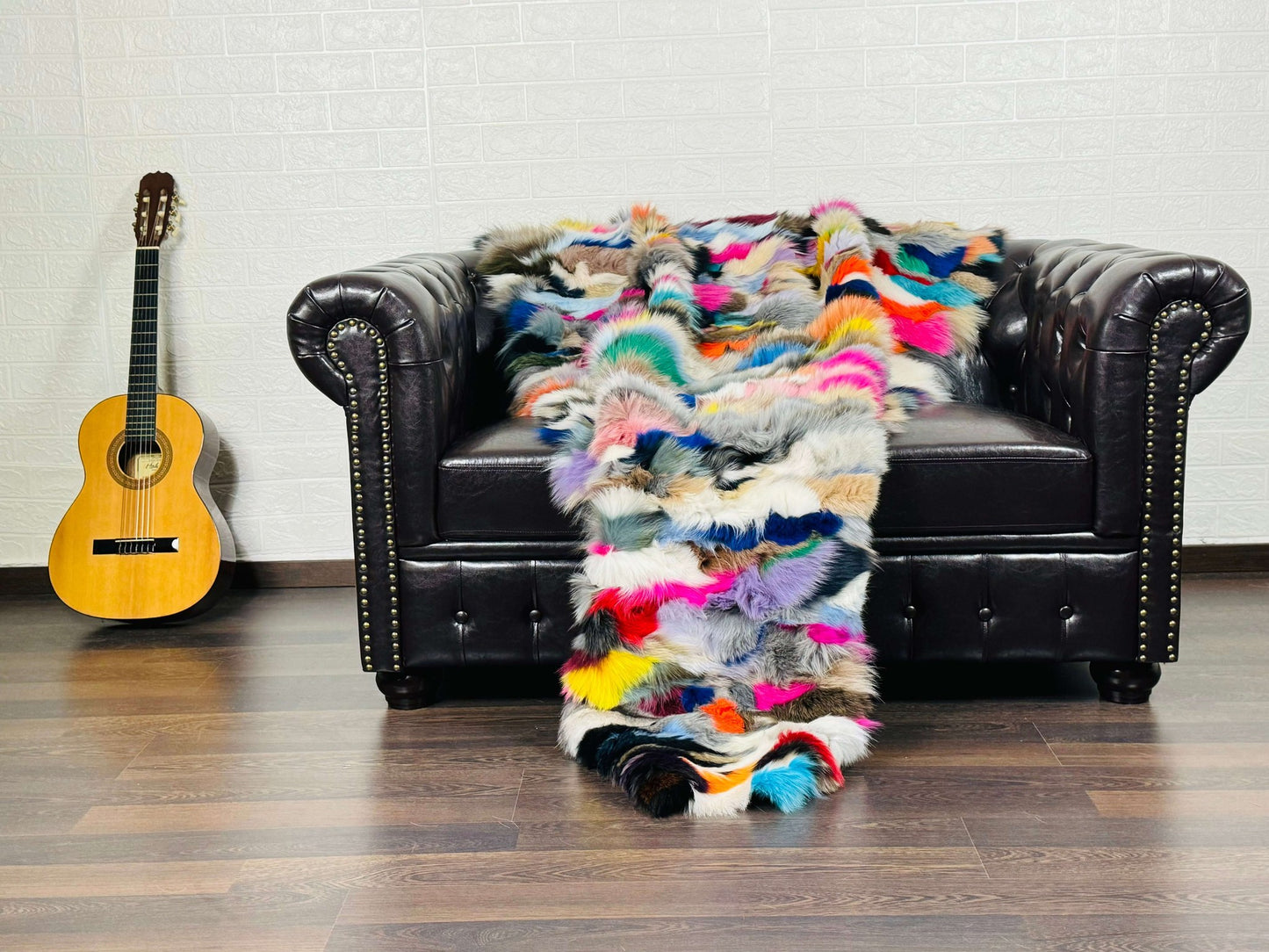 Fox Fur Blanket Throw Colorful - Tatifurs draped over a black couch, vibrant and luxurious multicolor design.