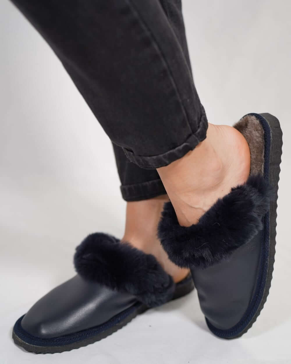 Sheepskin Wool Leather Fur Slippers Blue for Women worn with black jeans, showcasing luxurious comfort and style.