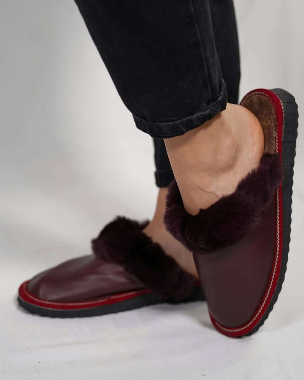 Sheepskin Wool Leather Fur Slippers Burgundy - Tatifurs worn by a woman, showcasing comfort and luxury.