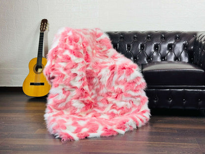 Fox Fur Blanket Throw Pink White - Tatifurs draped over a couch, showcasing its soft pink and white design.