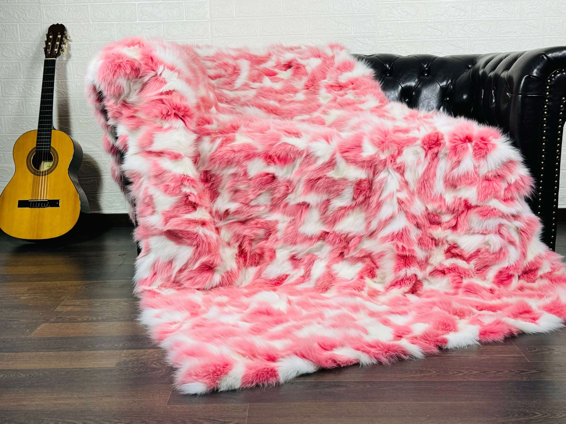 Fox Fur Blanket Throw Pink White - Tatifurs displayed on a couch, showcasing its soft pink and white colors.