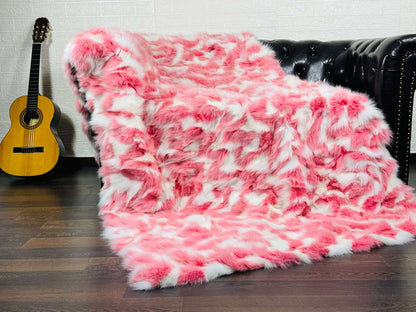 Fox Fur Blanket Throw Pink White - Tatifurs displayed on a couch, showcasing its soft pink and white colors.