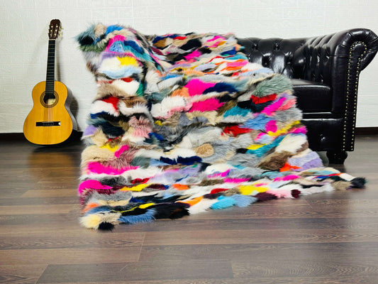 Fox Fur Blanket Throw Colorful - Tatifurs displayed on a sofa with a guitar, showcasing vibrant multicolored fur.