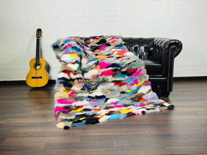 Fox Fur Blanket Throw Colorful - Tatifurs draped over a couch, showcasing vibrant multicolor patterns.